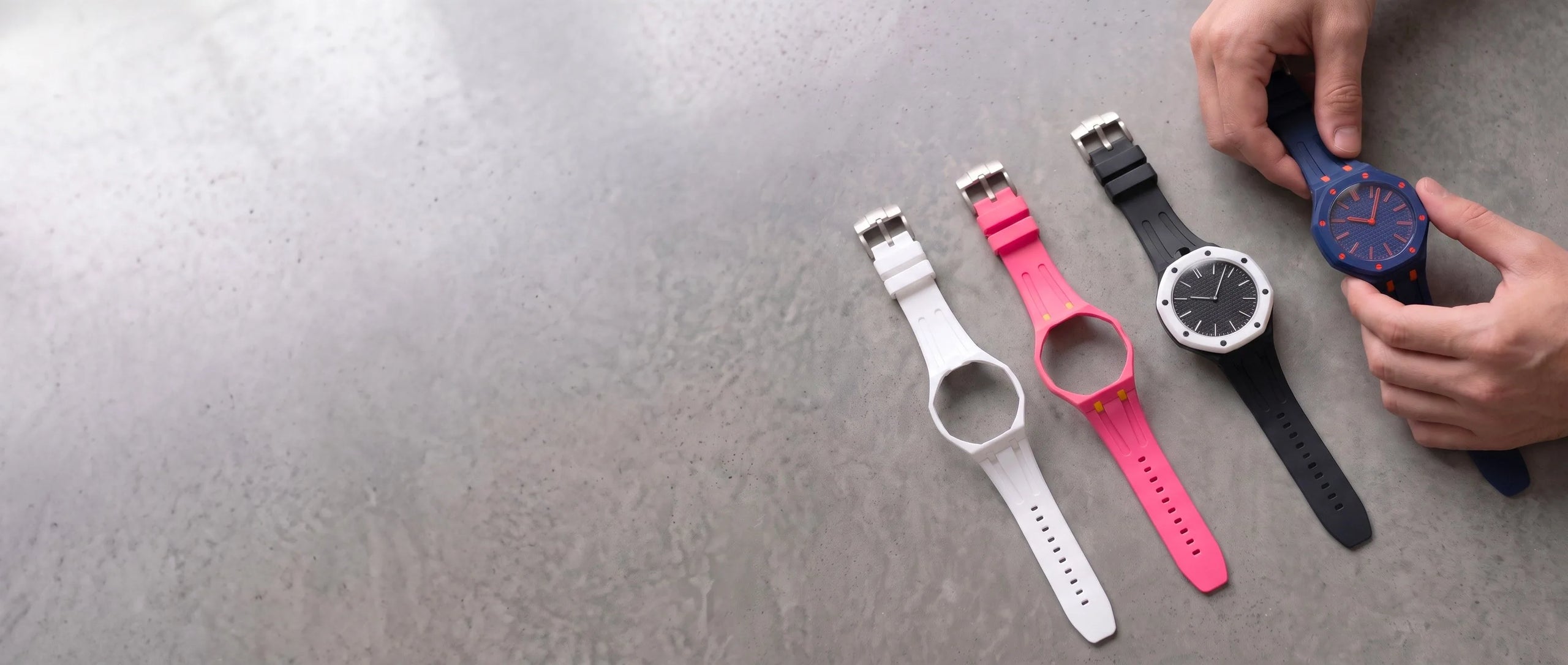 Bracelets Royal Pulse Snow, Pink Pop, Black Out et Blue Ice posés sur du béton ciré